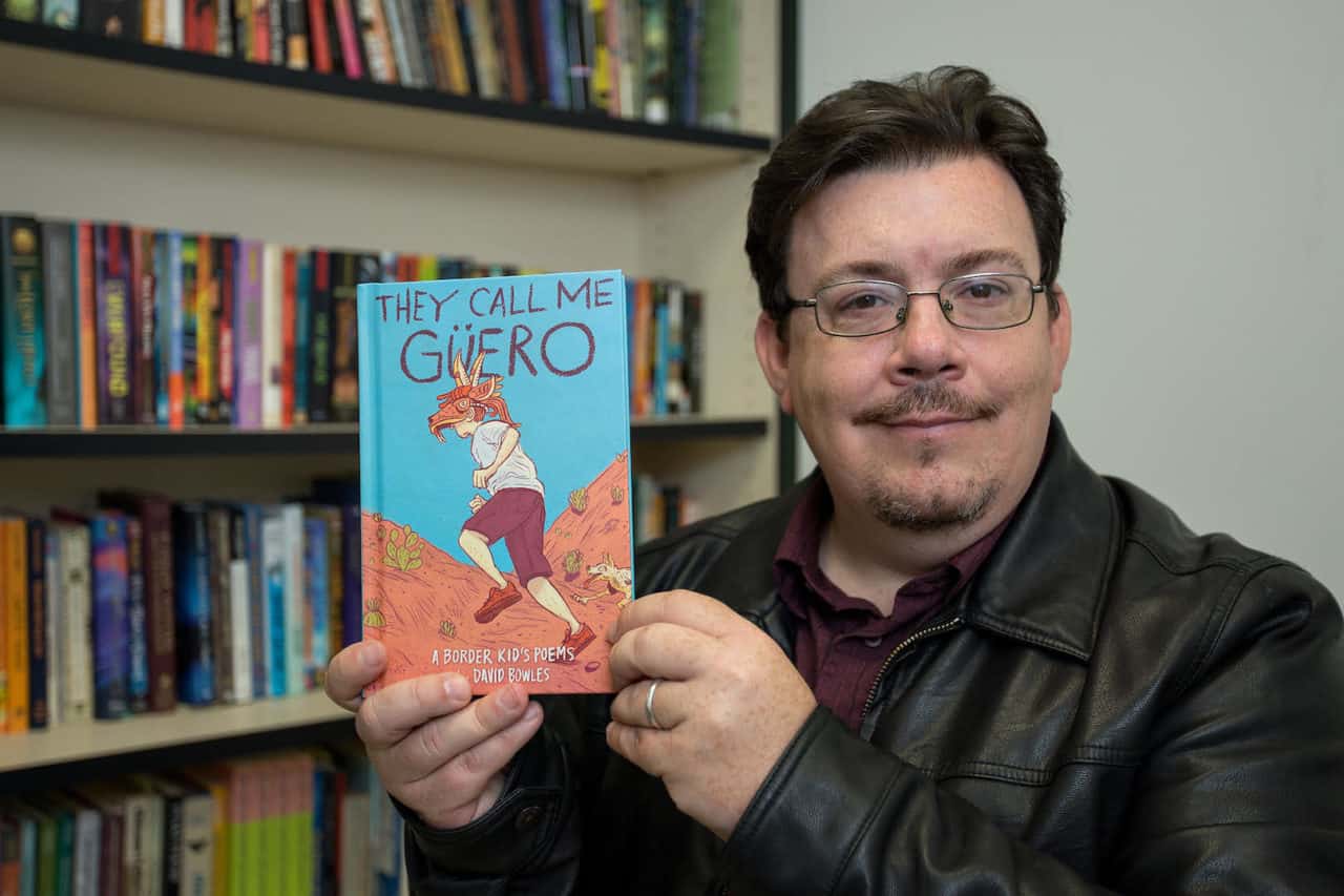 Featured: Dr. David Bowles, an associate professor in the University of Texas Rio Grande Valley Department of Literatures and Cultural Studies, with his book, “They Call Me Güero”, a novel in verse filled with slice-of-life poems illustrating life as a border kid – something for which 430,000 children in the Valley can relate. Photograph By PAUL CHOUY